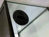 Black circular reptile tank lid on glass enclosure with mesh side panel