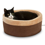 Black and white cat resting in a round heated mocha and beige pet bed