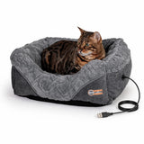 Tabby cat lying in a gray USB heated pet bed on a white background